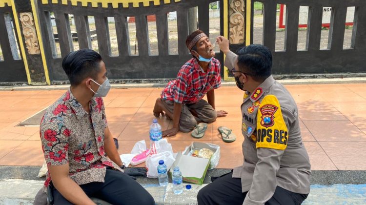 Penuh perhatian Alith Kapolres Bangkalan suapi dengan tangannya langsung seorang tunawisma. (Foto : klikku.net / ist / HumasPolres)