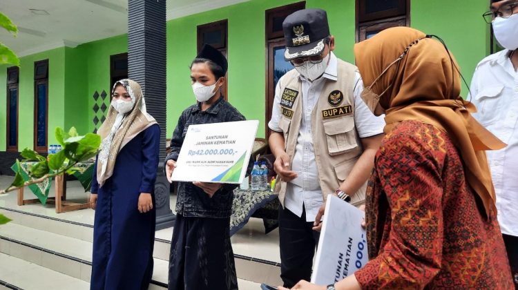 Bersemangat, kanan, Vinca Meitasari S.T.,M.M Kepala BPJS Ketenagakerjaan Madura bersama Ra Latif Bupati Bangkalan serahkan santunan kematian pada dua ahliwaris peserta BPJS Ketenagakerjaan di Desa Kanegarah Kecamatan Konang. Foto : klikku.net - Anam