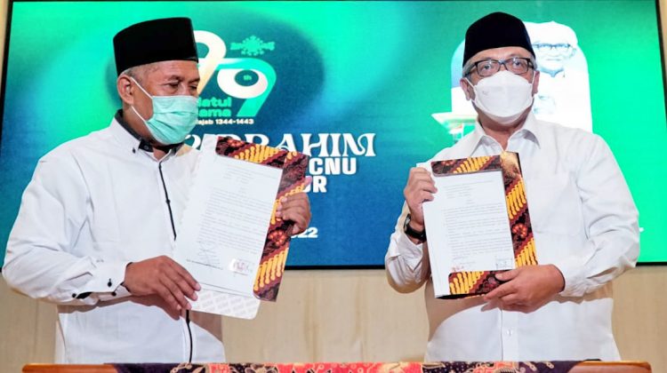 Kepala KPw BI Jatim Budi Hanoto (kanan) dan Ketua PWNU Jatim K.H. Marzuki Mustamar, menunjukkan naskah MoU