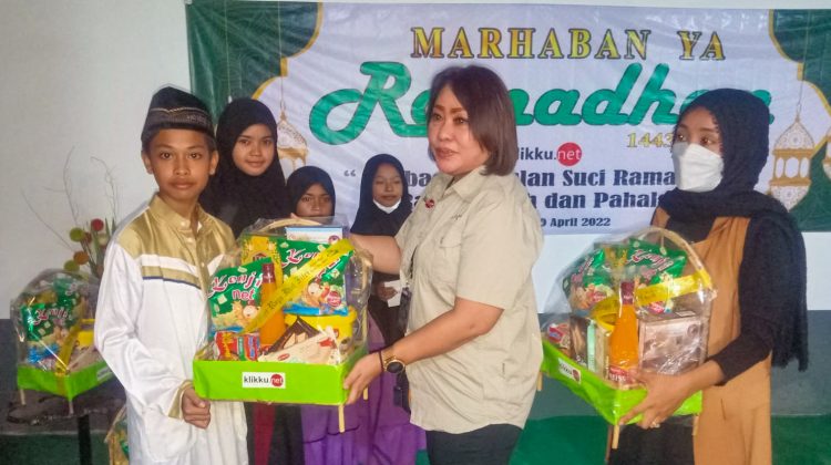 Komisaris PT. Klikku Media Pratama Hartini Sumitro (kedua kanan) secara simbolis membagikan bingkisan dan santunan pada anak yatim