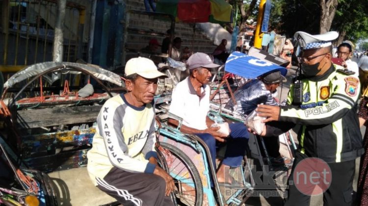 Personil Satlantas Polres Sampang Saat Membagikan Nasi Bungkus Kepada Tukang Becak (Doc. Anaf/klikku)