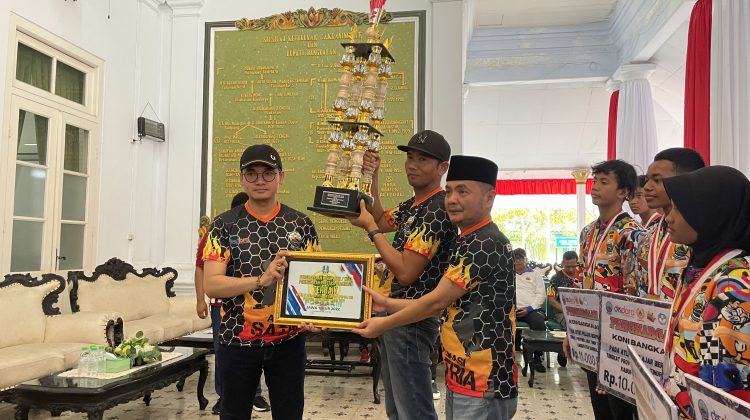 Penyerahan piagam dan piala penghargaan oleh Bupati R Abdul Latif pada Kadispora dan Ketua Umum Koni Bangkalan.

Foto : Anam dok klikku.net.