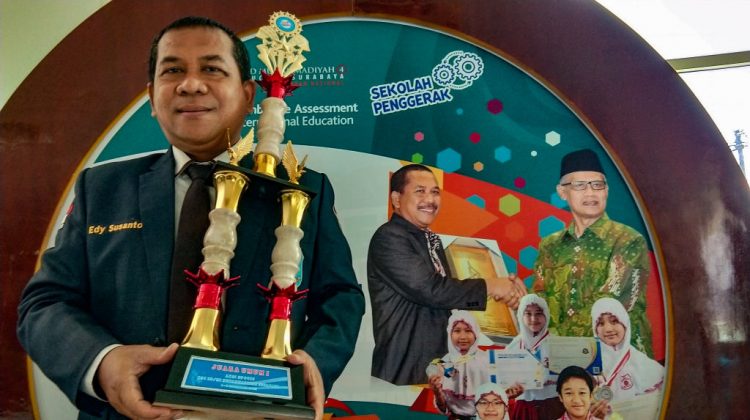 Kepala Sekolah SD Mudipat Surabaya Edy Susanto memamerkan Piala Juara Umum SPOTIC 2022