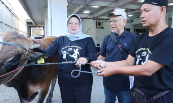 Kepala Dinas Kominfo Jatim, Sherlita Ratna Dewi Agustin (kiri) bersama panitia melakukan kegiatan pemotong hewan kurban yang akan didistribusikan