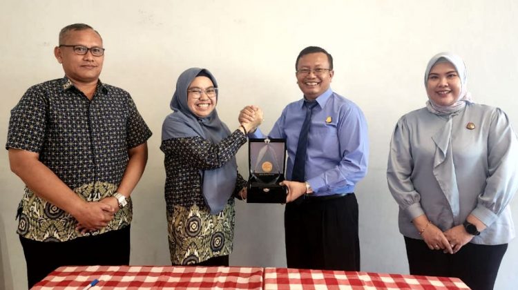 Kepala BPJS Kesehatan Cabang Surabaya Hernina Agustin Arifin (kedua kiri) & Kajari Surabaya Joko Budi Darmawan, bertukar cinderamata usai penandatanganan naskah MoU penanganan masalah hukum bidang perdata dan tata usaha negara