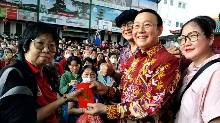 Ketua YHMCHI H. Abdullah Nurawi secara simbolis membagikan Angpao Imlek